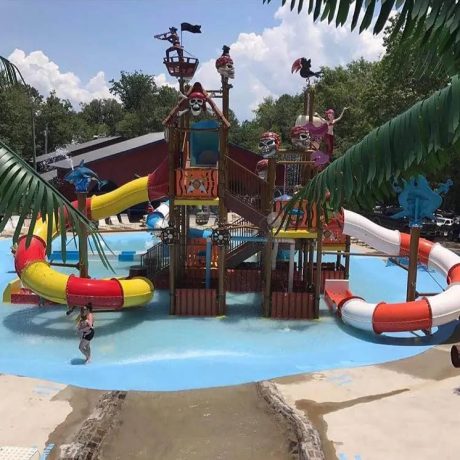 large structure with slides, pirate-themed decorations, and water pools