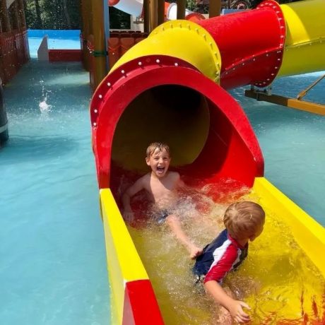 two children playing on a waterslide